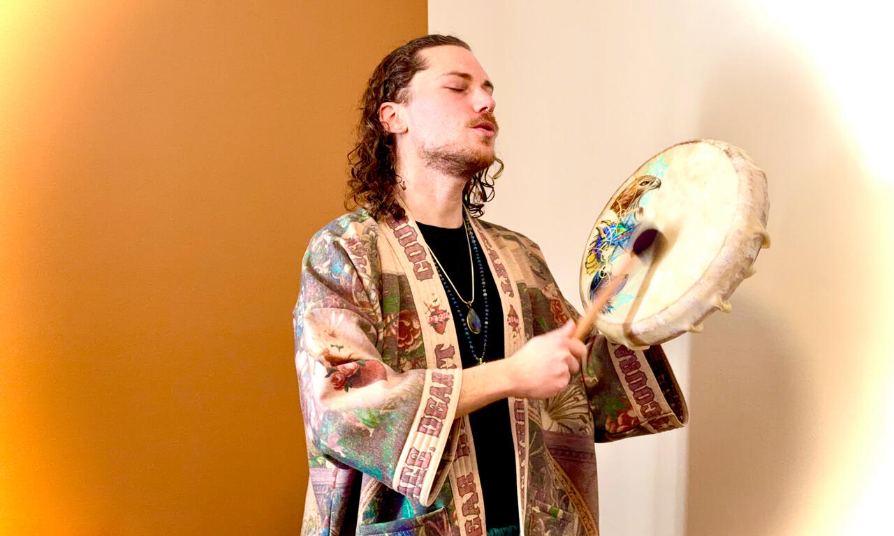 Devin Ryback, spiritual teacher and shamanic healer, playing a drum while singing